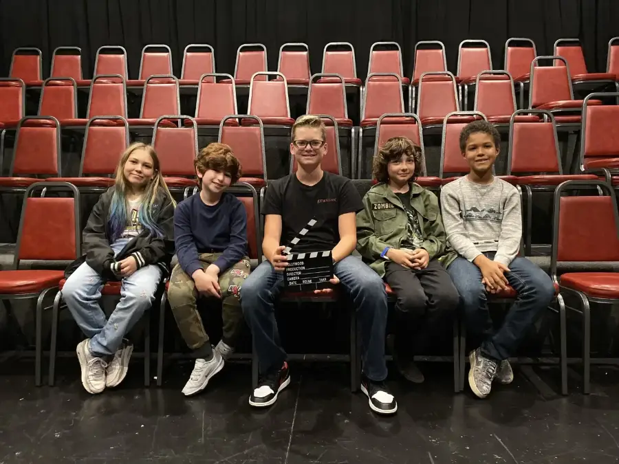 Campers in the theatre seats with a clapperboard