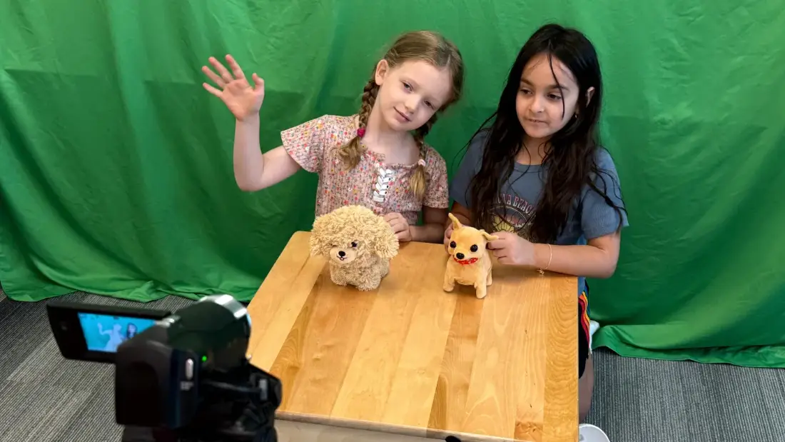 Two campers shooting a scene on the green screen stage