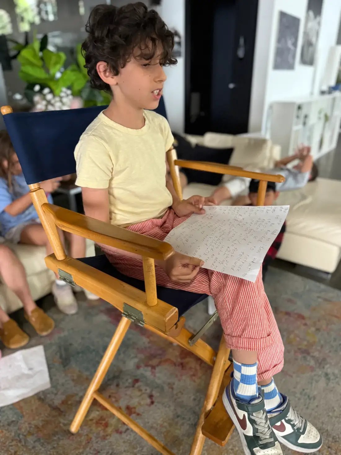 A camper reading his own script aloud from the director’s chair