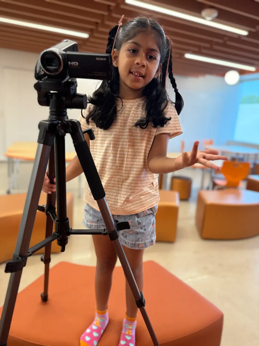 A young filmmaker setting up her own shot on a tripod