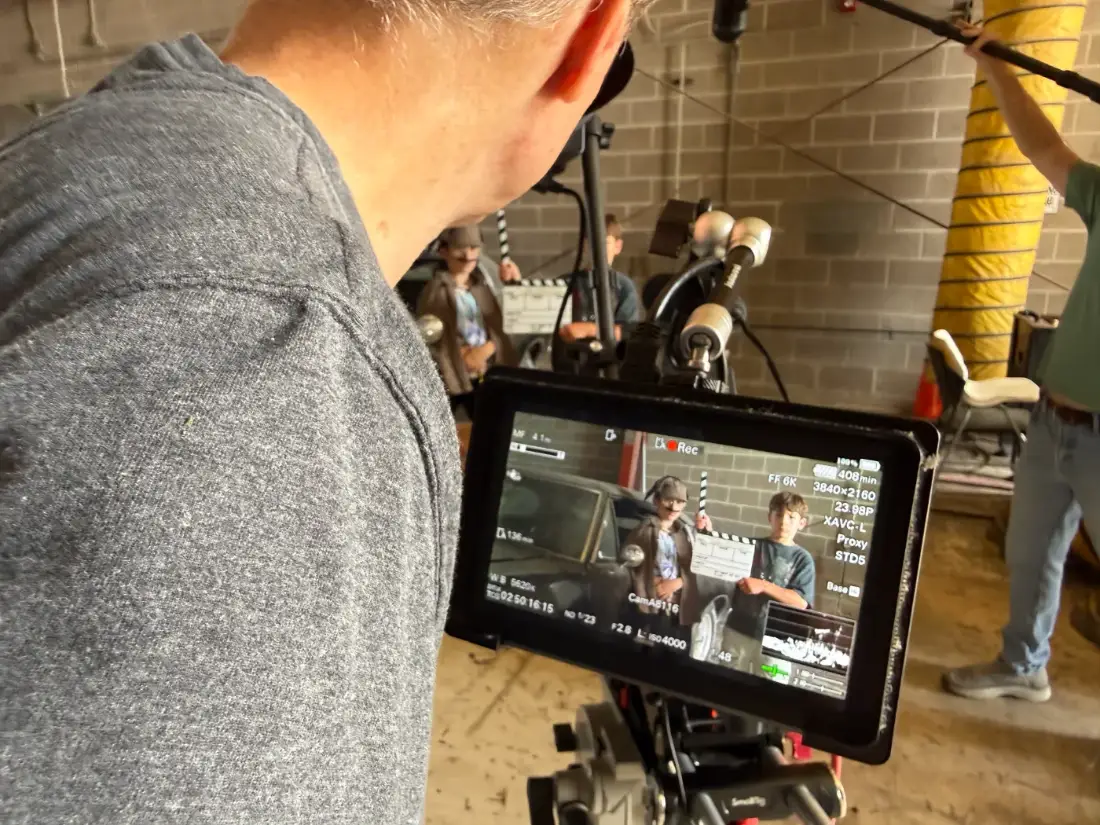An instructor watching a take on the monitor while the crew slates