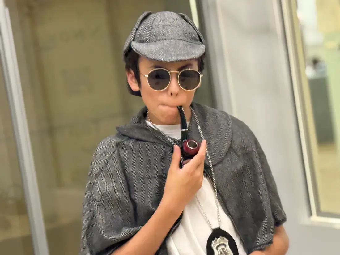 A camper in full detective costume, in character between takes