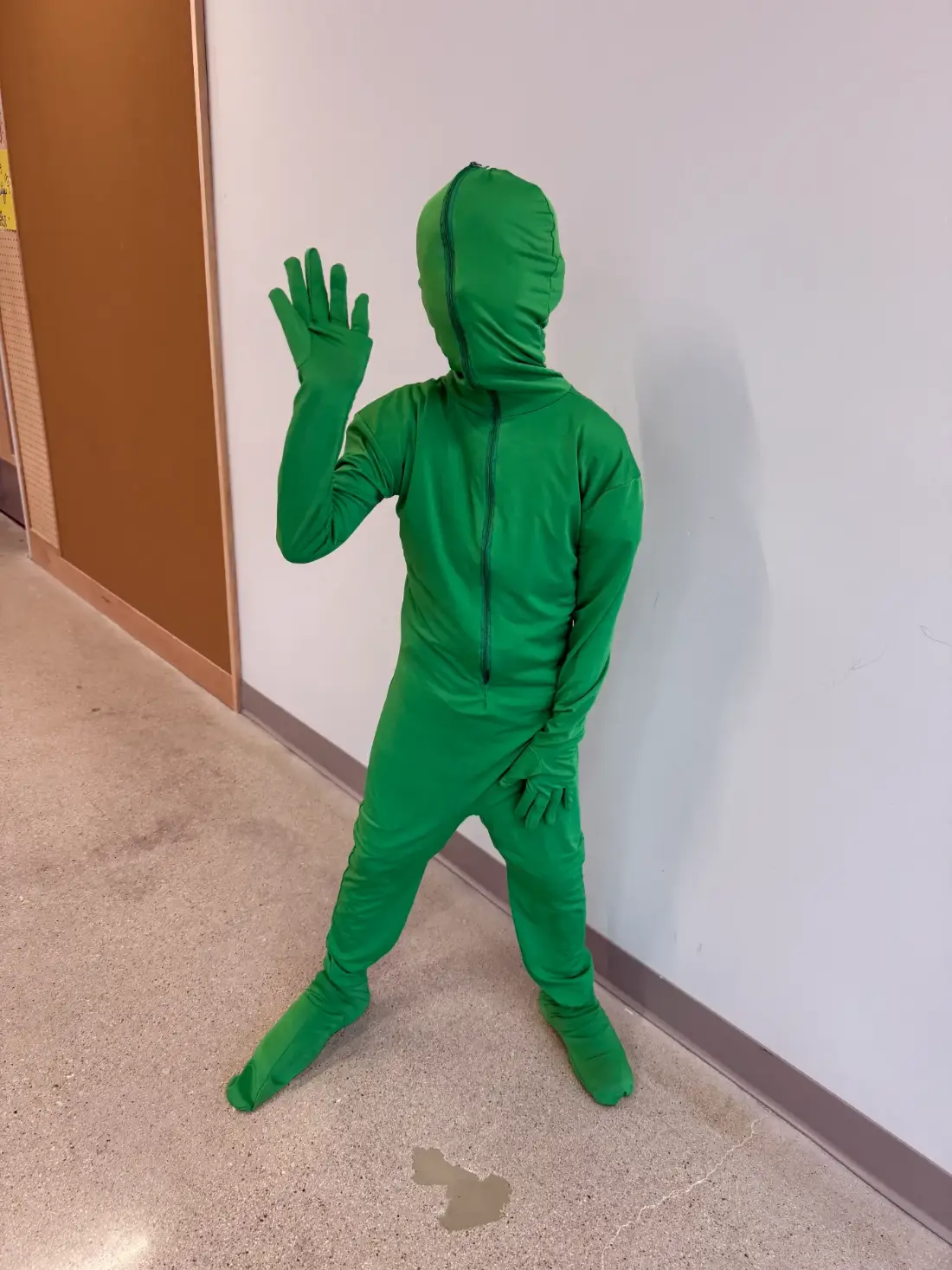 A camper in a green screen suit, ready to disappear
