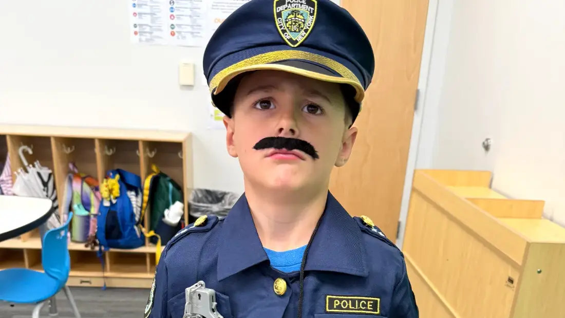 A young actor in costume and moustache, in character on set
