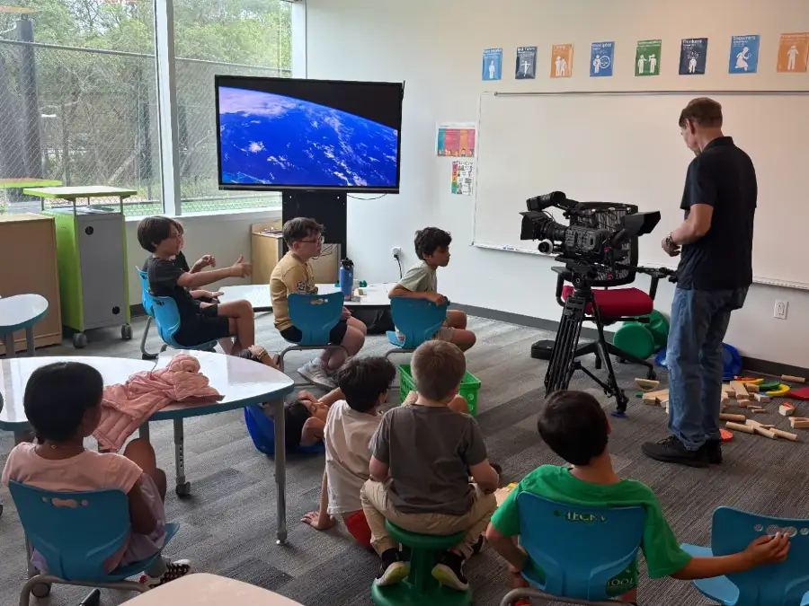 Campers watching a reference shot while an instructor sets up the camera