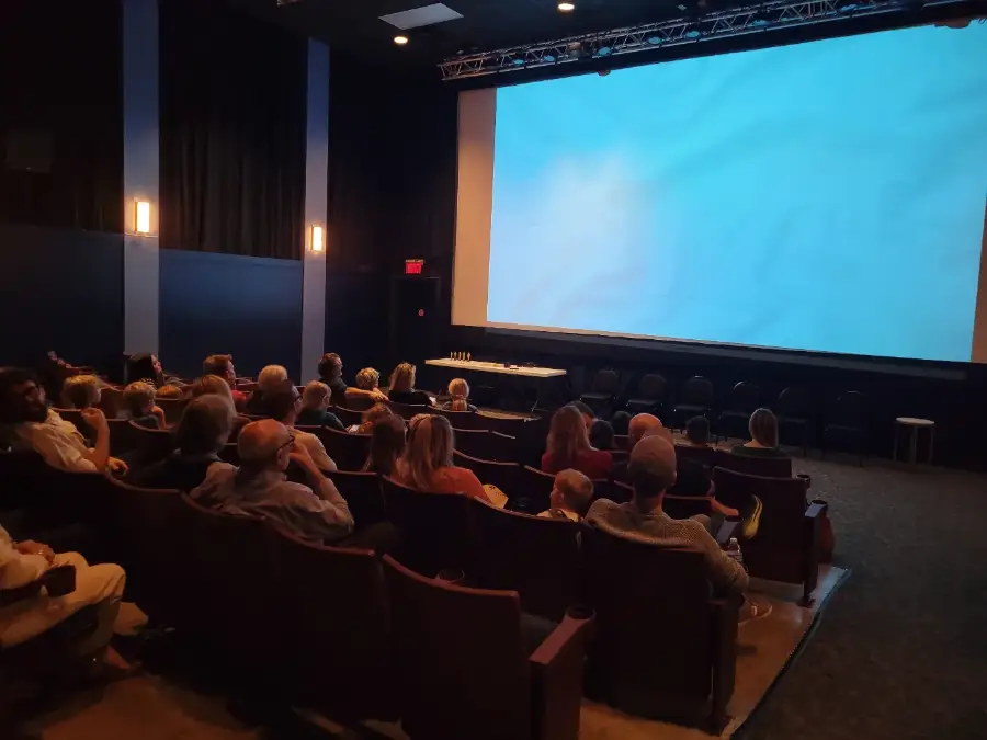 Families in a cinema watching the camper films on the big screen
